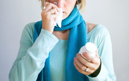 Woman wiping her nose and looking at immunity pills