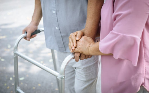 Seniors holding hands while using a walker